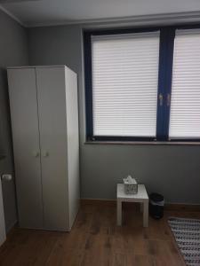 Una habitación con un armario y una mesa y dos ventanas. en Monteurwohnung Ferienwohnung, en Velbert