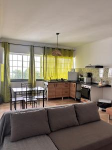 ein Wohnzimmer mit Sofa und Tisch in der Unterkunft Casa de Campos AL in Angra do Heroísmo