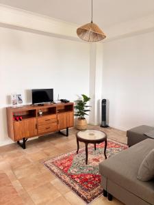 ein Wohnzimmer mit Sofa und Fernseher in der Unterkunft Casa de Campos AL in Angra do Heroísmo