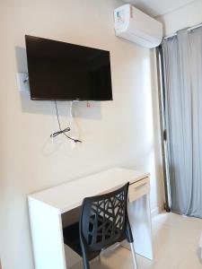 a desk with a computer monitor on a wall with a chair at Liszen flats in Porto De Galinhas +14 photos