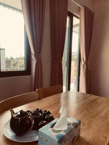Cloudy homestay في Bảo Lâm: طاولة عليها ابريق شاي وعلبة