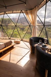 a room with a large window with a bed and chairs at Aguas Claras in Capilla del Monte +46 photos