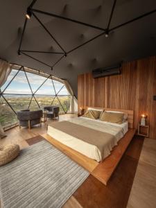 a bedroom with a large bed and a large window at Aguas Claras in Capilla del Monte