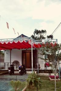 Cloudy homestay في Bảo Lâm: منزل أمامه خيمة حمراء