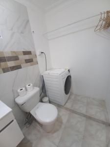 Un baño blanco con inodoro y televisor. en Casa Petter and Maria, 2end floor, en Santiago de los Caballeros 9 fotos más