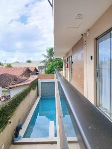 a view of a swimming pool from the balcony of a house at Liszen flats in Porto De Galinhas