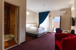 una habitación de hotel con una cama y un baño en Long Street Hotel, en Brasov