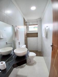 a bathroom with two sinks and a toilet in it at Liszen flats in Porto De Galinhas