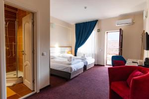 Una habitación de hotel con dos camas y una ventana. en Long Street Hotel, en Brasov 20 fotos más