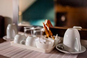 a table with a tray of cups and a tea pot at Pleasure Čair apartments in Niš