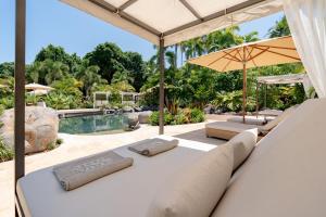 an outdoor patio with a couch and an umbrella at NALA Resort in Mission Beach