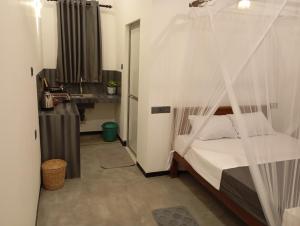 een slaapkamer met een bed met een klamboe bij Amandaa Homestay in Dikwella