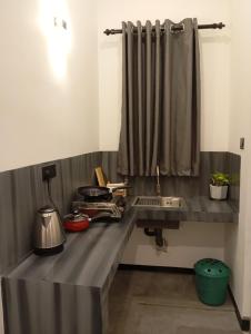 een aanrecht met een wastafel en een gordijn bij Amandaa Homestay in Dikwella