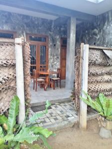 een uitzicht op een huis met een tafel en stoelen bij Amandaa Homestay in Dikwella