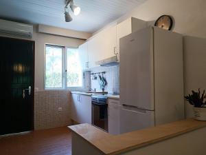 a kitchen with a white refrigerator and a stove at Lambriana's House beach front in Thessaloniki