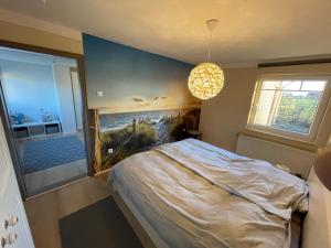 Funnenser Deichhaus في انجرلاند: غرفة نوم بها سرير ولوحة على الحائط