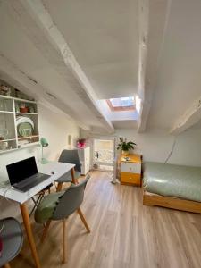 a room with a desk and a bed and a laptop at Buhardilla en Chueca, a pasos de Gran Vía in Madrid +13 photos