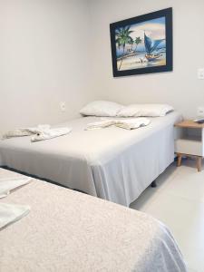 two beds sitting next to each other in a room at Liszen flats in Porto De Galinhas