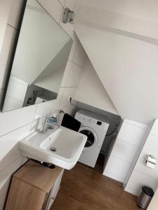Un baño con lavabo y lavadora. en Monteurwohung, Wohnung Möbliert, 55543 Bad Kreuznach, en Bad Kreuznach