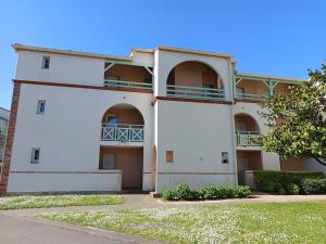a white building with balconies on the side at L'Orée du Golf - Balcon & Parking in Pornic +7 photos