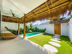 an outdoor patio with a pool and grass at Hoshi Villas in General Luna