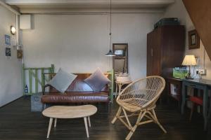 a living room with a leather couch and two chairs at LEJU 8 樂居 Loft Living by the River with Open Air Bath in Malacca