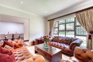 a living room with leather couches and a table at Winston Manor in Gillitts