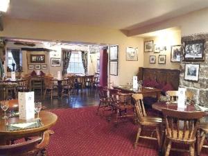 Un restaurante con mesas y sillas en una sala. en The Chequers Inn, en Froggatt