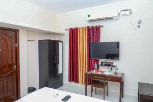 a room with a desk with a tv and a table with a deskngthngth at MP Villa in Puducherry