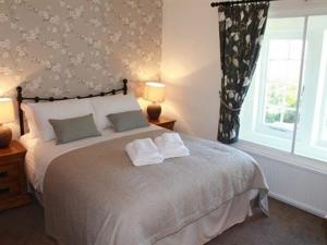 Un dormitorio con una cama con dos toallas encima. en The Chequers Inn, en Froggatt