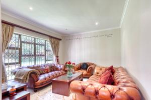 a living room with a leather couch and a table at Winston Manor in Gillitts