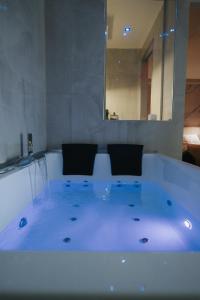 a white bath tub with two chairs in it at Artemide Resort Spa - Private Villa & Spa Suites in Lido Di Fondi