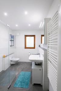 een witte badkamer met een wastafel en een spiegel bij BergSeeMomente in Breitbrunn am Chiemsee