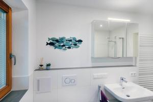 een witte badkamer met een wastafel en een spiegel bij BergSeeMomente in Breitbrunn am Chiemsee +11 foto's