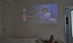 a person laying on a bed with their feet on a wall at Metsämansikan helmi I Free parking & Netflix I 5G in Espoo