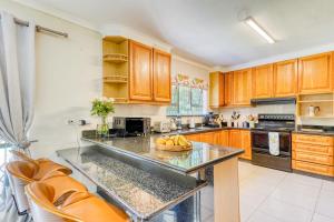 a kitchen with wooden cabinets and a bowl of fruit on a counter at Winston Manor in Gillitts +26 photos