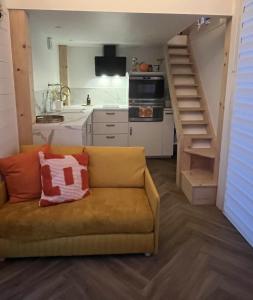 a living room with a couch and a kitchen at La Tiny du Rioux in Lagnieu