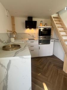 a kitchen with a sink and a stove top oven at La Tiny du Rioux in Lagnieu +4 photos