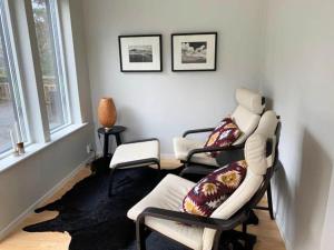 Cottage near the beach with guesthouse SE09165 في Sörtegen: غرفة معيشة بها ثلاثة كراسي وأريكة
