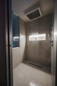 a shower with a glass door in a bathroom at Artemide Resort Spa - Private Villa & Spa Suites in Lido Di Fondi +23 photos