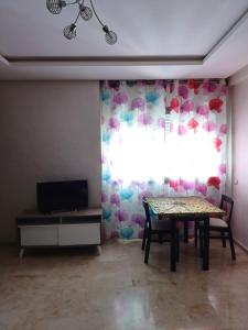 a dining room with a table and a window at Apartment kamal park G39 in Mohammedia