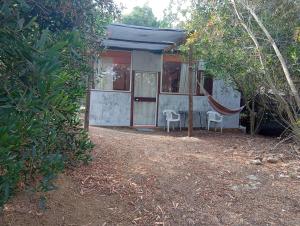 a small house with a hammock in front of it at El Romance in Jaureguiberry