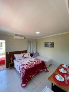 een slaapkamer met een bed en een tafel met borden erop bij Suítes Concha do Sol in Maragogi