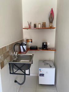 een keuken met een wastafel en een kleine koelkast bij Suítes Concha do Sol in Maragogi