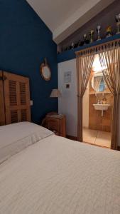 a bedroom with a bed and a bathroom with a sink at La ruchette in Riez