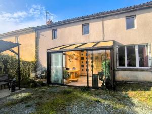 Gîte Le Coquelicot Jardins de Marie في Cerizay: تمديد منزل مع حديقة شتوية