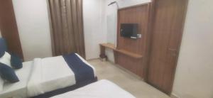 Una televisión o centro de entretenimiento en Hotel R K LUXE