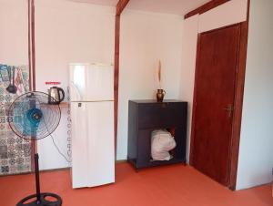 a room with a refrigerator and a fan next to a door at El Romance in Jaureguiberry