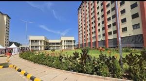 Un parque con flores frente a algunos edificios. en Makasembo furnished apartments one bedroom, en Kisumu