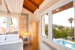 Un dormitorio con una cama y una ventana grande. en Villa Suites Lagonisi Luxury, en Lagonisi 50 fotos más